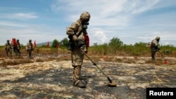 FILE - Soldiers detect Unexploded Ordnance (UXO) and defoliant Agent Orange in Vietnam's central Da Nang City.
