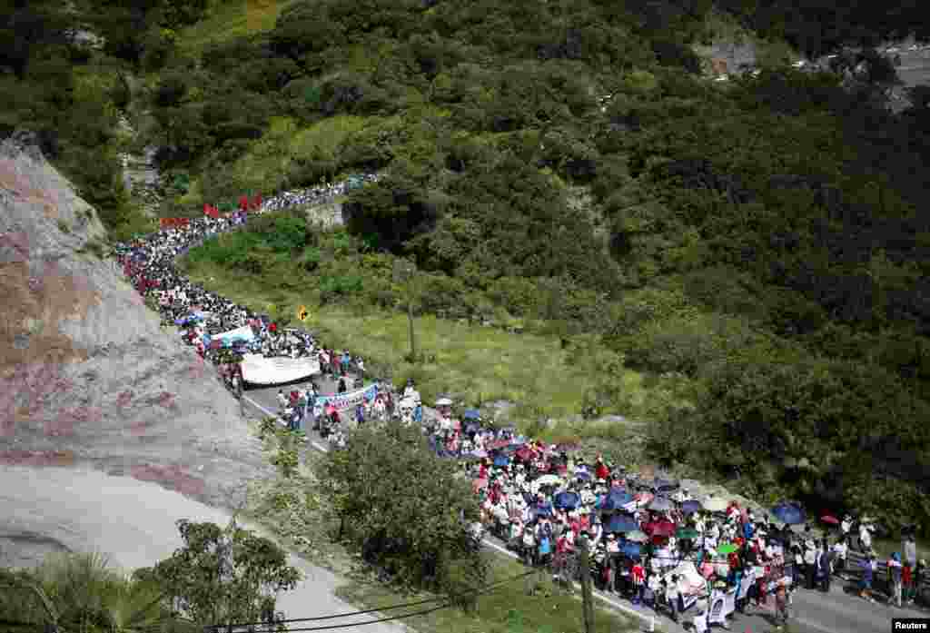 People march along Tixtla road in Chilpancingo as part of a demonstration to demand information about 43 missing students, in the Mexican state of Guerrero, Oct. 23, 2014.