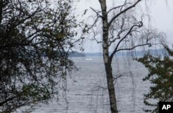 In this amateur photo provided by Sweden's armed forces and distributed by the TT News Agency on Sunday, Oct. 19, 2014, a partially submerged object is visible in the water at center, in the Stockholm archipelago, Sweden.