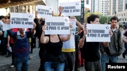 Residents hold up signs that read, "Metro workers: The people support you," outside Ana Rosa subway station during the fifth day of metro worker's strike in Sao Paulo, Brazil, June 9, 2014.