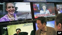 Visitors watch TV screens broadcasting news of Libyan leader Moammar Gadhafi speaking to his supporters, bottom left, during the China Content Broadcasting Network Expo in Beijing, March 23, 2011 (file photo)