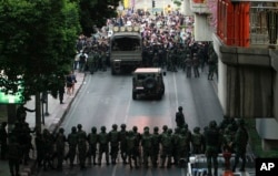 FILE - Protesters, background, confront Thai soldiers blocking the road during a demonstration in Bangkok, Thailand, May 26, 2014.