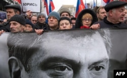 FILE - Russia's opposition supporters carrying a banner bearing a portrait of Kremlin critic Boris Nemtsov during a march in central Moscow, March 1, 2015.