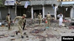 Afghan security force members inspect the site of a suicide attack in Jalalabad, April 18, 2015. 