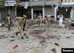 Afghan security force members inspect the site of a suicide attack in Jalalabad, April 18, 2015.