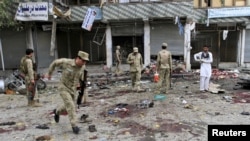 Afghan security force members inspect the site of a suicide attack in Jalalabad, April 18, 2015. 
