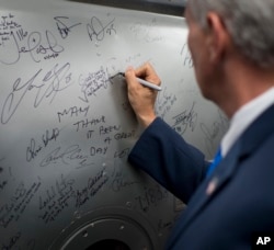 In the tradition of others, Vice President Mike Pence signs a hatch from a space station training module mockup, June 7, 2017, at NASA's Johnson Space Center in Houston, Texas.
