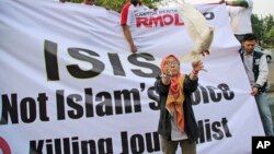 FILE - A Muslim woman releases a dove as a symbol of peace during a rally against the Islamic State group in Jakarta, Indonesia, Sept. 5, 2014.