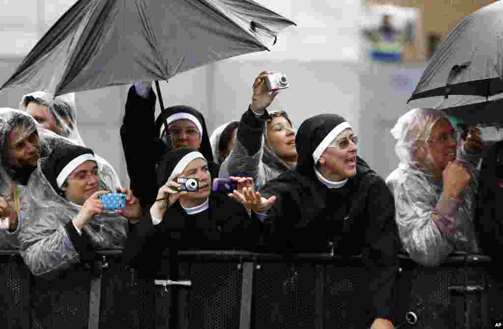 Nuns wave at the Pope as he drives by in his popemobile as he leaves Aparecida, Brazil, July 24, 2013.