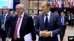 European Commission President Jean-Claude Juncker, left, and European Council President Donald Tusk, right, walk through the atrium during an EU summit in Brussels, Oct. 19, 2017.