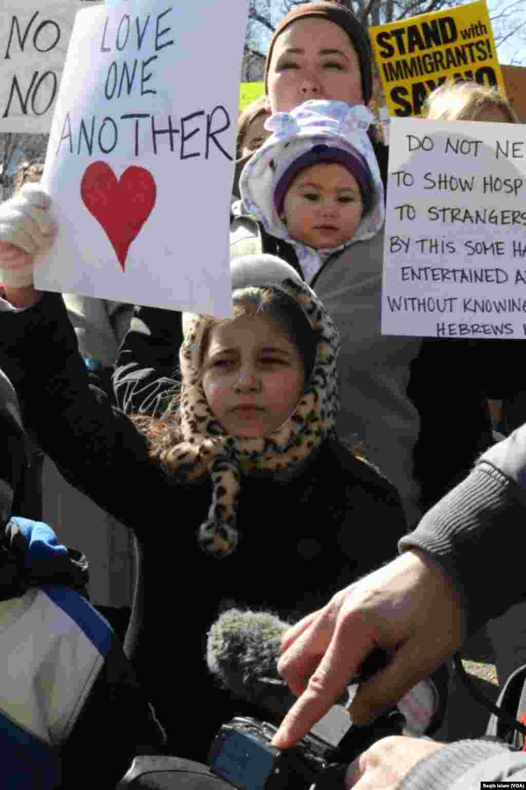 Families with children holding signs participated in support of immigrants and refugees, Feb. 4, 2017, in Washington, D.C. (S. Islam/VOA)