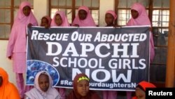 Schoolgirls wait for the arrival of Nigeria's president, Muhammadu Buhari, at the Government Girls Science and Technical College in Dapchi, Nigeria, March 14, 2018.