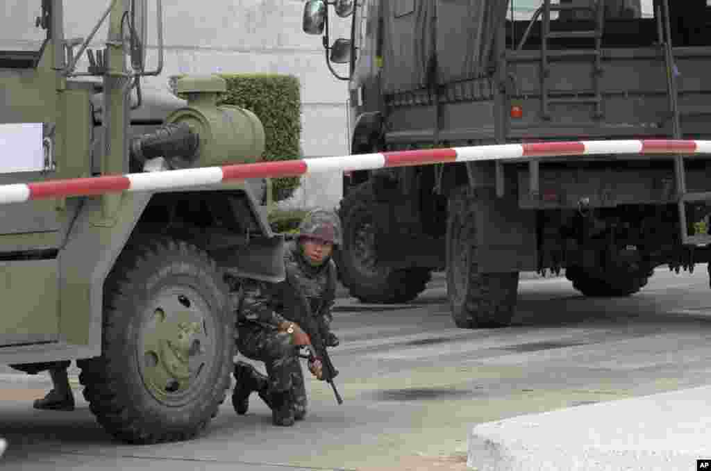 An armed soldier takes a position behind a military vehicle in the compound of the Army Club shortly after the military staged a coup,&nbsp;in Bangkok, May 22, 2014.