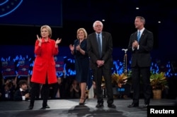 From left, Hillary Clinton, Iowa Democratic Chairwoman Andy McGuire, Bernie Sanders and Martin O'Malley greet the crowd at the Jefferson-Jackson Dinner in Des Moines, Iowa, Oct. 24, 2015.