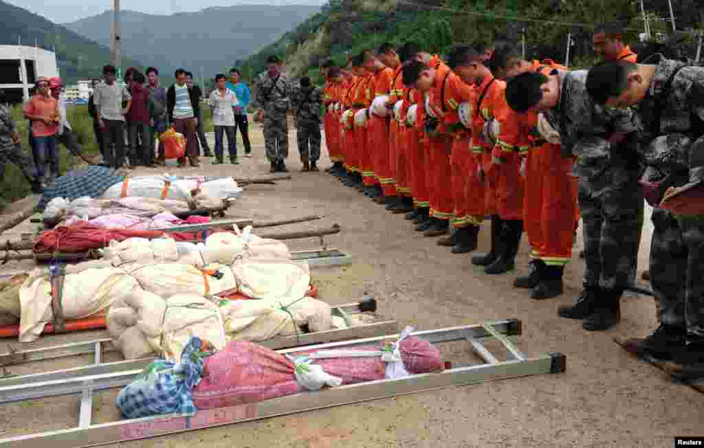 Rescuers bow to pay tribute to residents who were killed during an earthquake in Longtoushan township, Ludian county, Yunnan province, Aug. 4, 2014.&nbsp;