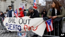 FIL E - Protesters express their opposition to the fact the the Federal Reserve bank bailed out Wall Street but not Puerto Rico outside International House, in New York, April 7, 2016.