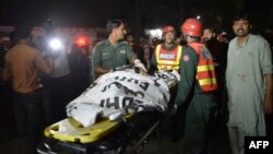 Pakistani rescuers use a stretcher to shift a body from a bomb blast site in Lahore on March 27, 2016. 