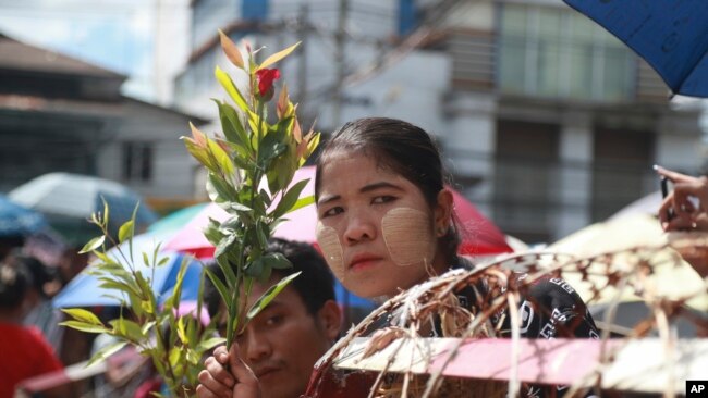 Anggota keluarga dari para tahanan yang mendekam di Lapas Insein di Yangon, Myanmar, tampak menunggu di luar kantor lapas pada 19 Oktober 2021. Pemerintah Myanmar memberikan amnesti kepada ribuan tahanan yang ditahan karena keterlibatannya di aksi protes anti pemerintah sejak Februari lalu. (Foto: AP)