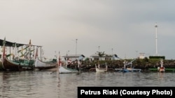 Perahu dan kapal penangkap ikan milik nelayan Muncar, Banyuwangi, berada di pelabuhan Muncar yang dikelilingi tanggul pelindung ombak, 5 Januari 2019. (Foto: Petrus Riski/VOA)