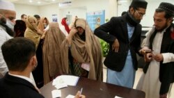 People register themselves to receive a dose of COVID-19 vaccine at a vaccination center, in Peshawar, Pakistan, Jan. 21, 2022.