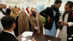 People register themselves to receive a dose of COVID-19 vaccine at a vaccination center, in Peshawar, Pakistan, Jan. 21, 2022.