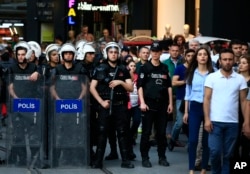 Turkish police officers secure central Istanbul's Istiklal Avenue, the main shopping road, as protesters stage a demonstration against a decision by Turkey's parliament to amend the constitution, May 20, 2016.