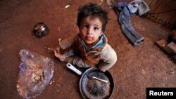 A Syrian refugee child eats inside his family's tent at an informal settlement in Deir al-Ahmar, Bekaa valley, Sept.16, 2014. 