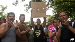 Migrantes cubanos sostienen un cartel exigiendo derechos humanos en Peñas Blancas, Costa Rica, en la frontera con Nicaragua.