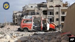 FILE - In this photo provided by the Syrian Civil Defense group known as the White Helmets, a destroyed ambulance is seen outside the Syrian Civil Defense main center after airstrikes in Ansari neighborhood in the rebel-held part of eastern Aleppo, Syria, Sept. 23, 2016.