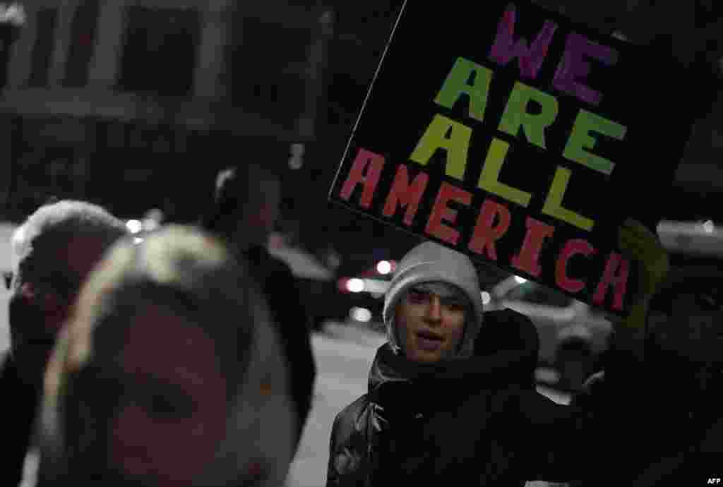 Demonstrators hold up signs during an interfaith solidarity protest against President Donald Trump&#39;s executive immigration ban, outside the Downtown Islamic Center in Chicago, Illinois.