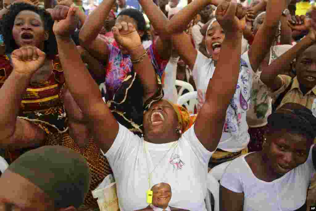 Woman react as they gather at a local market area to celebrate the victory of Ivory Coast&#39;s President Alassane Ouattara after elections in Abidjan.