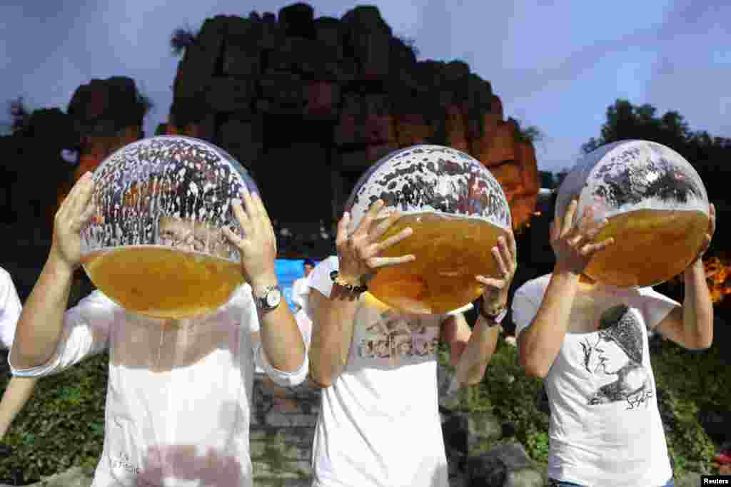 People drink beer from fish bowls at a beer drinking competition in Hangzhou, Zhejiang province, China, July 21,2018.