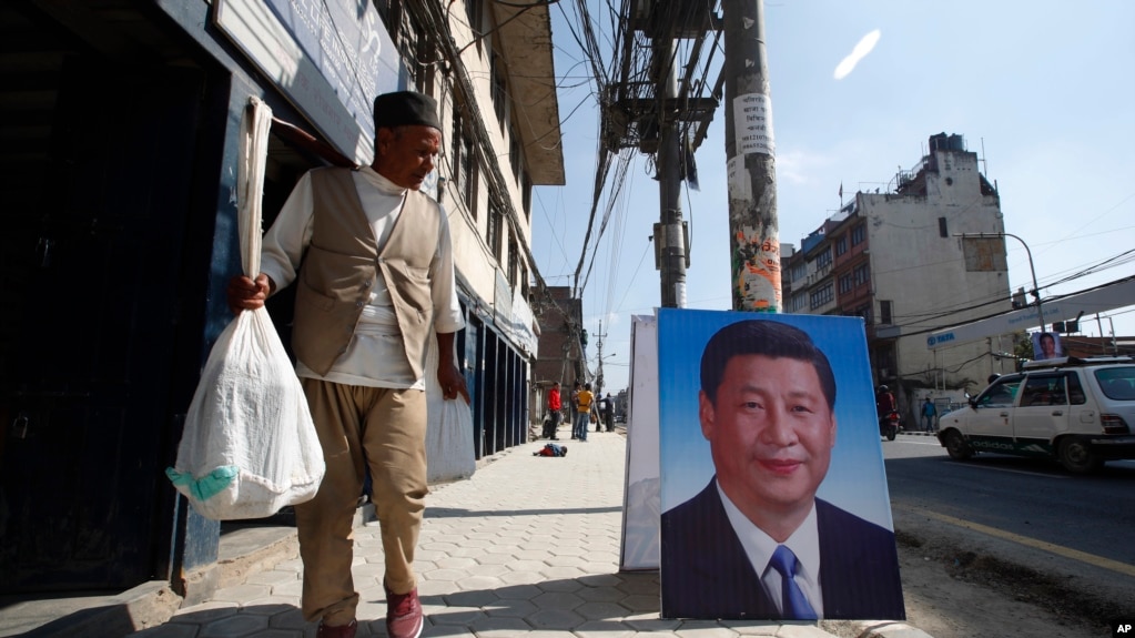 资料照片:一名尼泊尔男性路过摆在加德满都街头的中国国家主席习近平的肖像。（2019年10月11日）(photo:VOA)