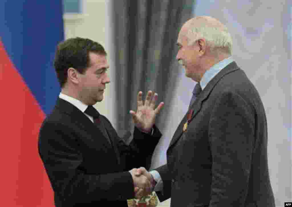 Russian President Dmitry Medvedev, left, presents famous Russian filmmaker and actor Nikita Mikhalkov with a medal during an award ceremony in the Kremlin in Moscow, Thursday, Dec. 30, 2010. (AP Photo/Alexander Natruskin, Pool)