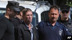 EgyptAir plane hijacking suspect Seif Eddin Mustafa, second left, is escorted by Cyprus police officers as he leaves a court after a remand hearing as authorities investigate him on charges including hijacking, illegal possession of explosives and abduction in the Cypriot coastal town of Larnaca, March 30, 2016. 