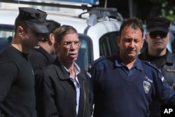 EgyptAir plane hijacking suspect Seif Eddin Mustafa, second left, is escorted by Cyprus police officers as he leaves a court after a remand hearing as authorities investigate him on charges including hijacking, illegal possession of explosives and abduction in the Cypriot coastal town of Larnaca Wednesday, March 30, 2016.