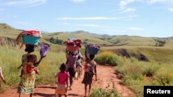 Women and their children walk to the river in the locust infested area in the Vakinankaratra region of central Madagascar, March 30, 2013.