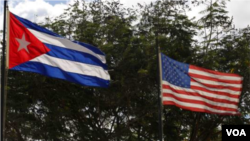 FILE - The national flags of Cuba and the United States.