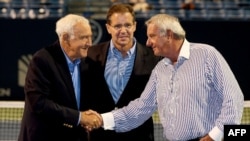 After being inducted into the International Tennis Hall of Fame, Mike Davies, left, thanks Butch Buchholz, right, chairman of the New Haven Open at Yale, and Mark Stenning, CEO of the hall, in New Haven, Conn., Aug. 24, 2014.