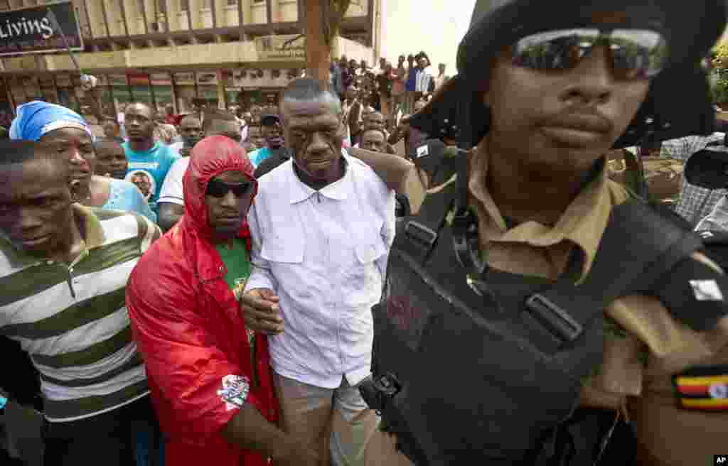 Kizza Besigye , au centre, est arrêté par la police après avoir tenté de protester avec ses partisans le long d&#39;une rue dans le centre de Kampala, Ouganda, 15 février 2016.