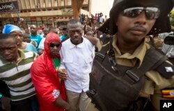 Leading opposition leader and presidential candidate Kizza Besigye, center, is arrested by riot police after attempting to walk with his supporters along a street in downtown Kampala, Uganda Monday, Feb. 15, 2016.