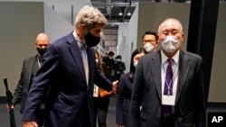 China's chief negotiator Xie Zhenhua, right, walks with John Kerry, U.S. special presidential e0nvoy for climate, at the COP26 U.N. Climate Summit in Glasgow, Scotland, Nov. 12, 2021.