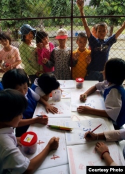 Stateless children in Thailand peer into the classroom of a school they are barred from attending. (Joseph Quinnell)