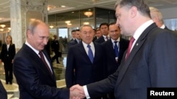 Rusya Cumhurbaşkanı Vladimir Putin ve Ukrayna Cumhurbaşkanı Petro Poroşenko Minsk'deki zirvede el sıkışırken