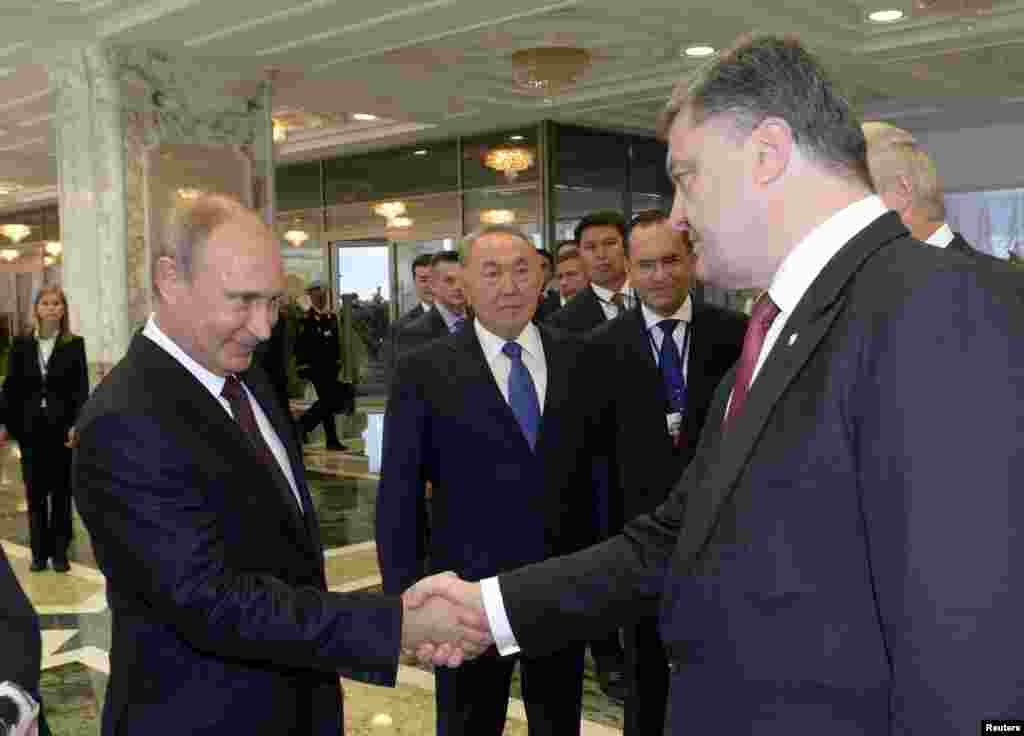 President Vladimir Putin (left) shakes hands with his Ukrainian counterpart Petro Poroshenko, as Kazakh President Nursultan Nazarbayev stands nearby, in Minsk, Aug. 26, 2014.