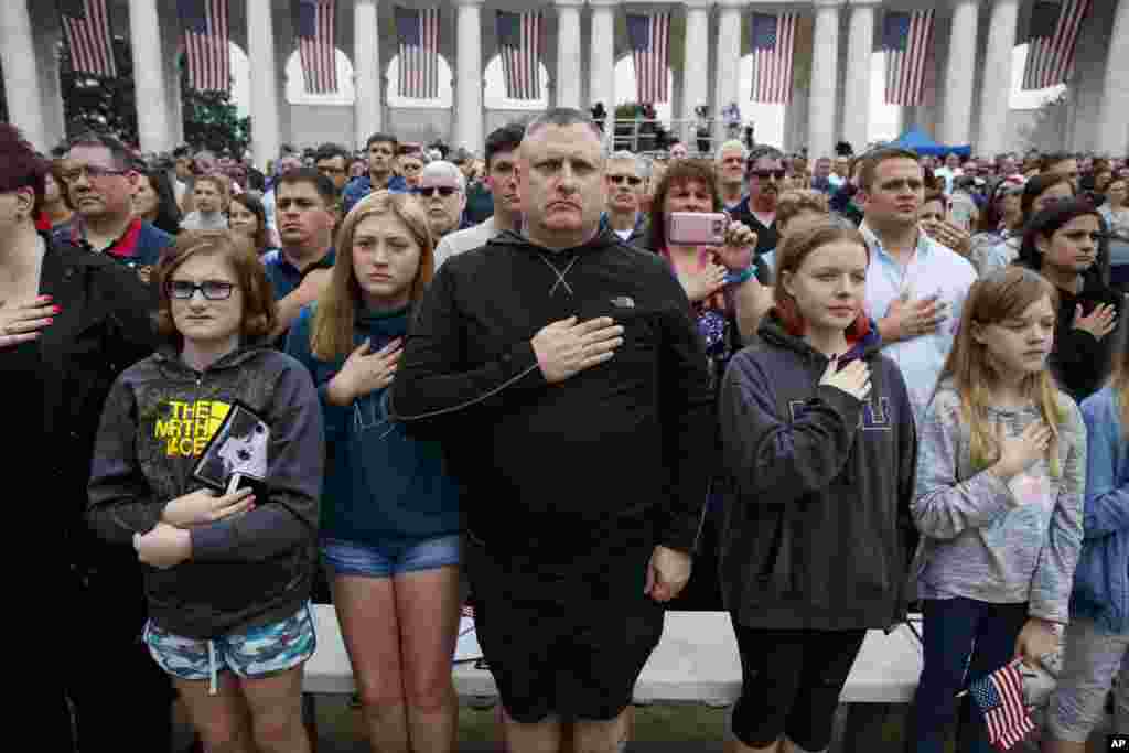 People gather to pay tribute to the more than 400,000 servicemen and women who lost their lives during the war, as &quot;Taps&quot; is played during a Memorial Day ceremony at Arlington National Cemetery, May 28, 2018, in Arlington, Virginia.