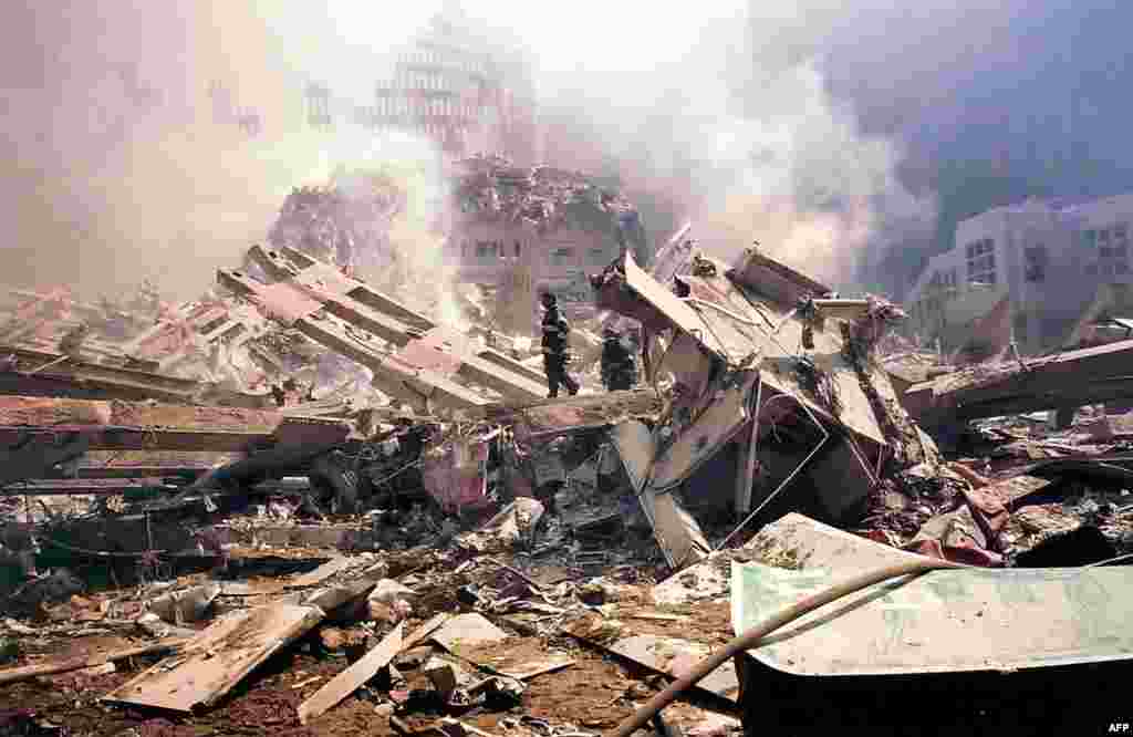 (FILE)Firemen walk amid the smouldering rubble of the World Trade Center following a terrorist attack 11 September 2001 in New York. A hijacked plane crashed into and destroyed the landmark structure. AFP PHOTO/Alexandre Fuchs (Photo by ALEXANDRE FUCHS / AFP)