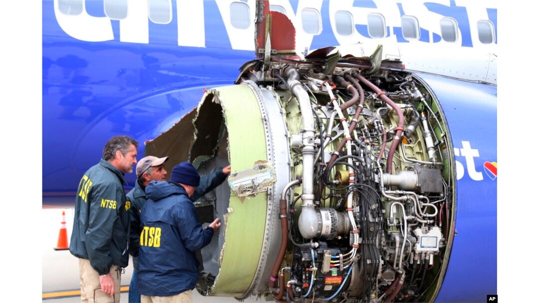 National Transportation Safety Board investigators examine damage to the engine of the Southwest Airlines plane that made an emergency landing at Philadelphia International Airport in Philadelphia, April 17, 2018.