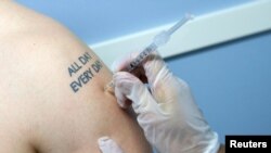 FILE - Influenza virus injection at a Walgreen's pharmacy in New York.