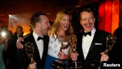 Dari kiri ke kanan: Aktor Aaron Paul, Anna Gunn, dan Bryan Cranston dari serial "Breaking Bad" berfoto dengan piala Emmy Awards yang mereka dapatkan Senin (25/8). 